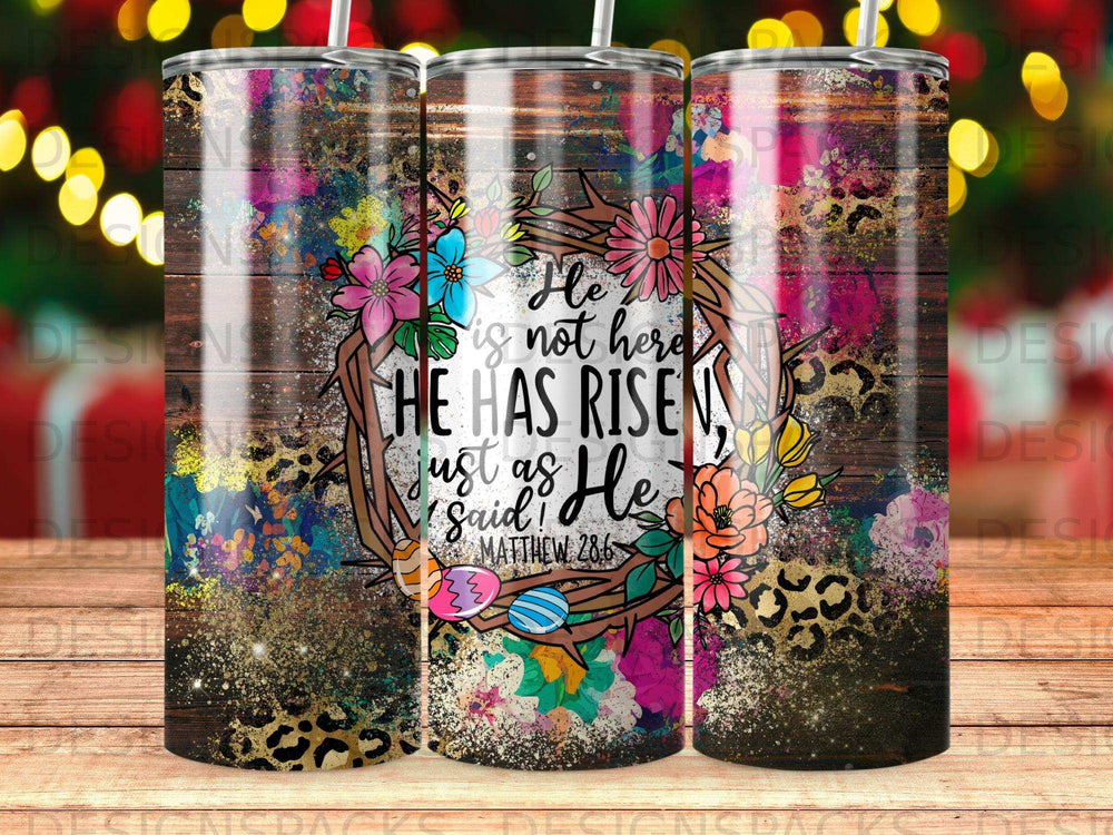 Tumbler with colorful floral wreath, text "He is not here, He has Risen!"