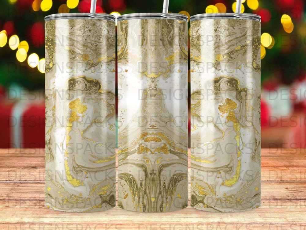 Three tumblers with marbled gold and beige patterns on a wooden surface.