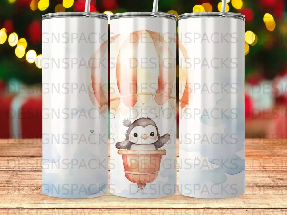 Tumbler with a penguin in a hot air balloon and repeated "DESIGNSPACKS" text.