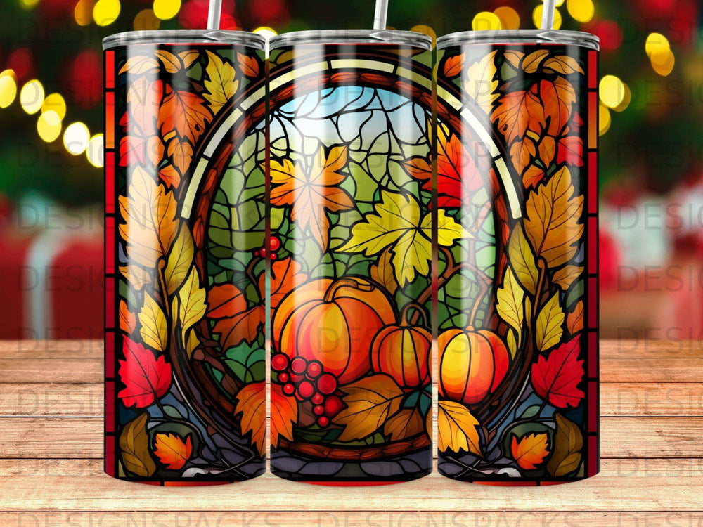 Stained glass tumbler with pumpkins and autumn leaves, backlit.