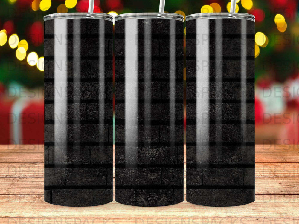 Black brick pattern tumbler with blurred holiday lights in the background.