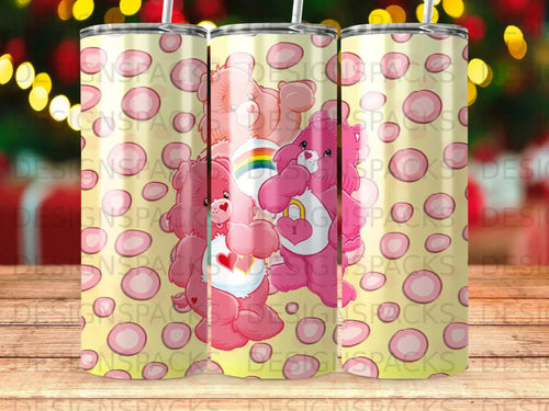 Three pink Care Bears with hearts and rainbows on a yellow, patterned background.