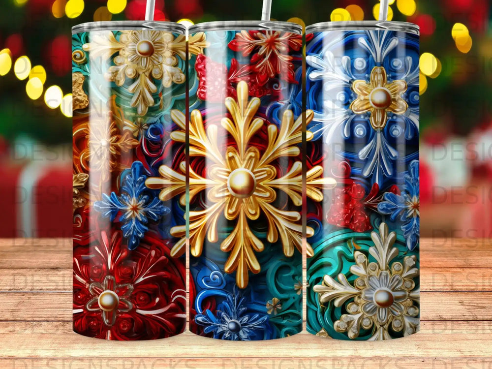Three tumblers with ornate snowflake designs in red, blue, and teal.