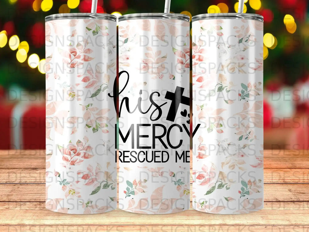 Tumbler with "His Mercy Rescued Me" text and floral pattern.