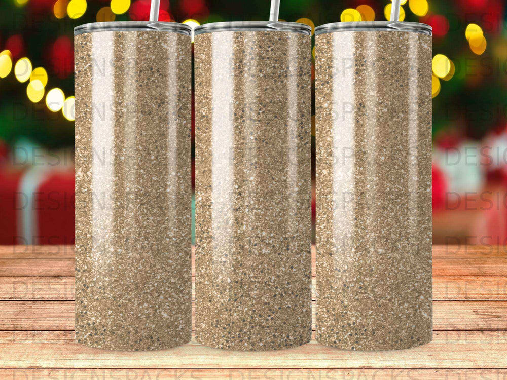 Three tall, skinny tumblers with a glittery gold design and metal straws.