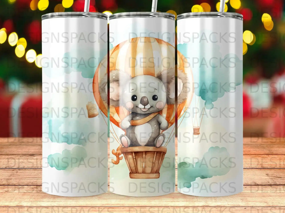 Koala in hot air balloon surrounded by watercolor clouds and decorative elements.