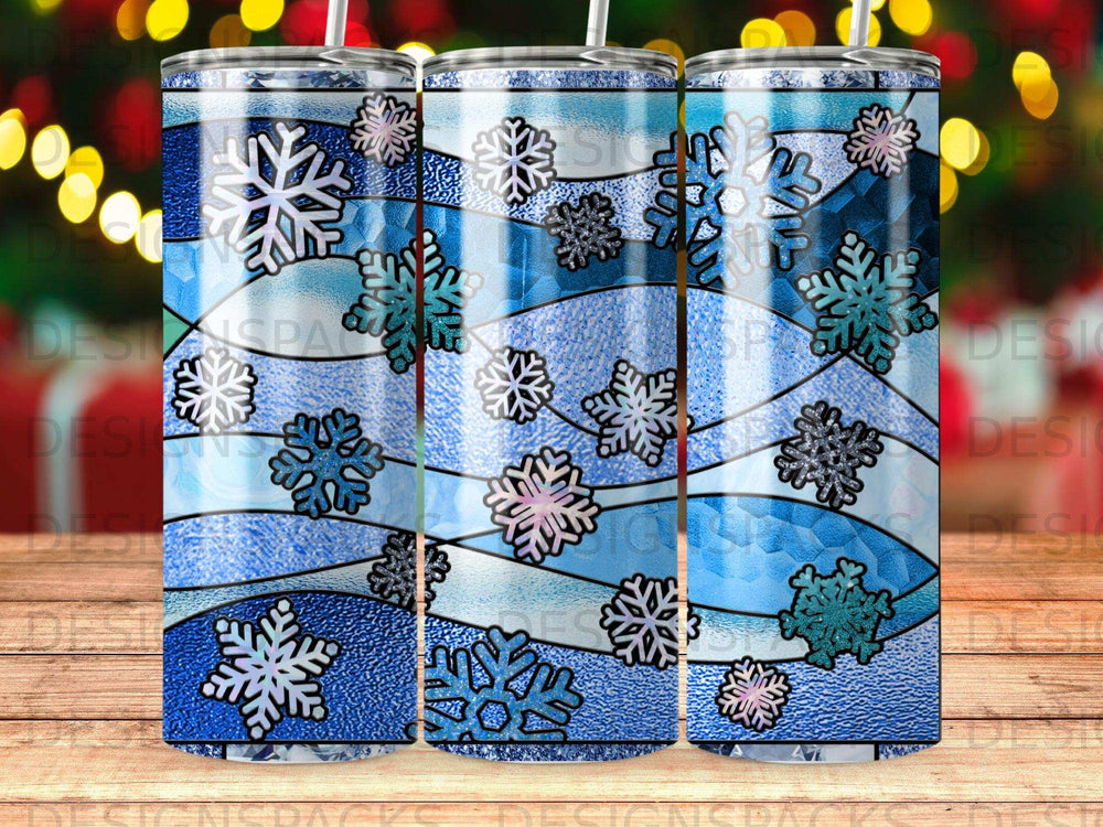 Blue and white snowflakes on a tumbler, with blurred bokeh lights background.