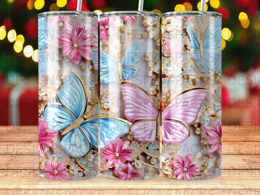 Three tumblers with blue and pink butterflies, flowers, and gems.