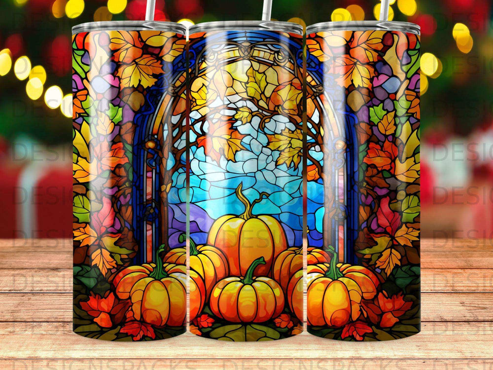 Stained glass pumpkin art on a tumbler, set against a blurred festive background.