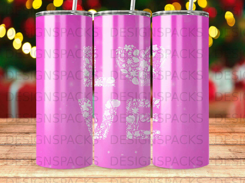 Pink tumbler with a white floral heart design, repeating "DESIGNSPACKS".