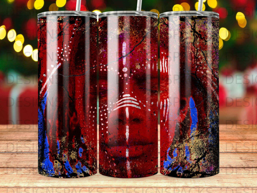 Red tribal face pattern on three tumblers with blurred bokeh background.