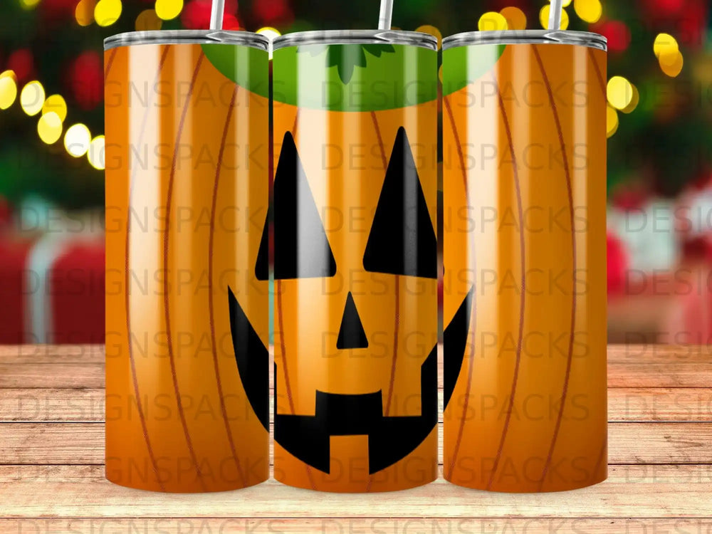 Three orange pumpkin-themed tumblers with straws, set against a blurred background.