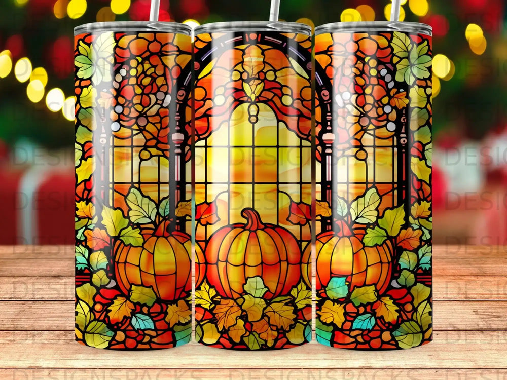 Stained glass tumbler with pumpkins, autumn leaves, and festive bokeh lights.