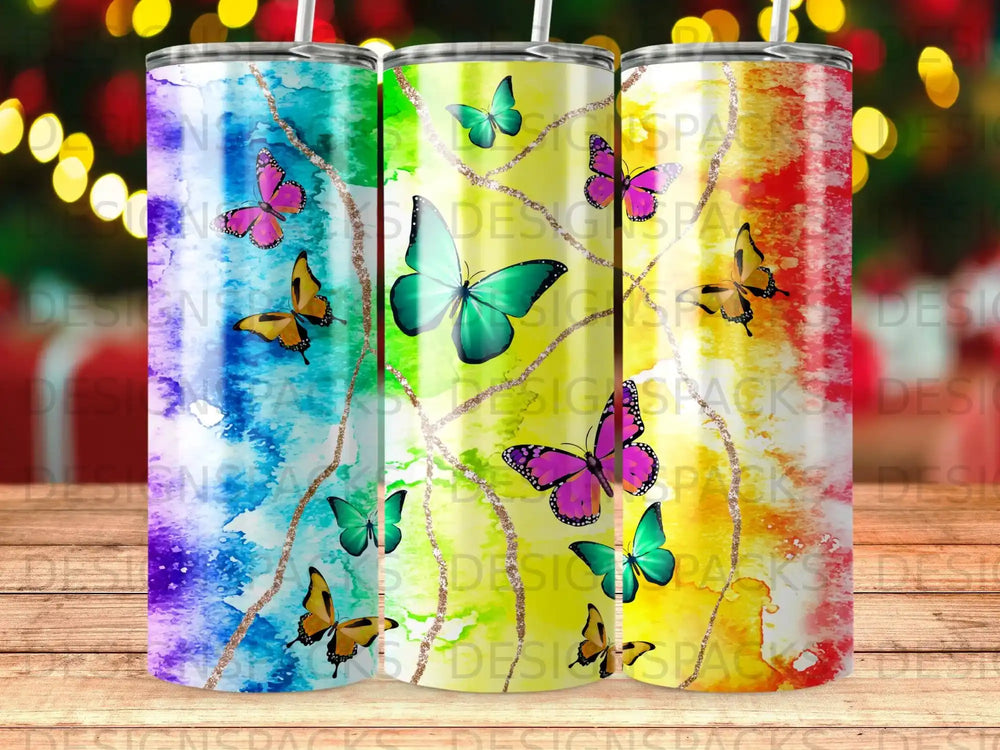 Three tumblers with butterfly and glitter designs, varying in color.