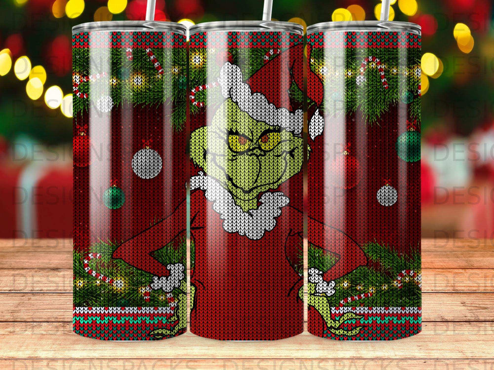 The Grinch in a Santa hat and red sweater on a holiday tumbler.