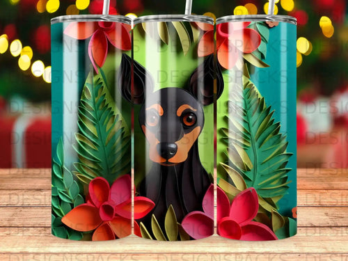 Black and tan dog peeking through tropical leaves and flowers on a tumbler.