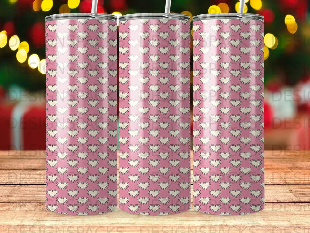 Pink tumbler with a repeating pattern of white hearts and outlines.