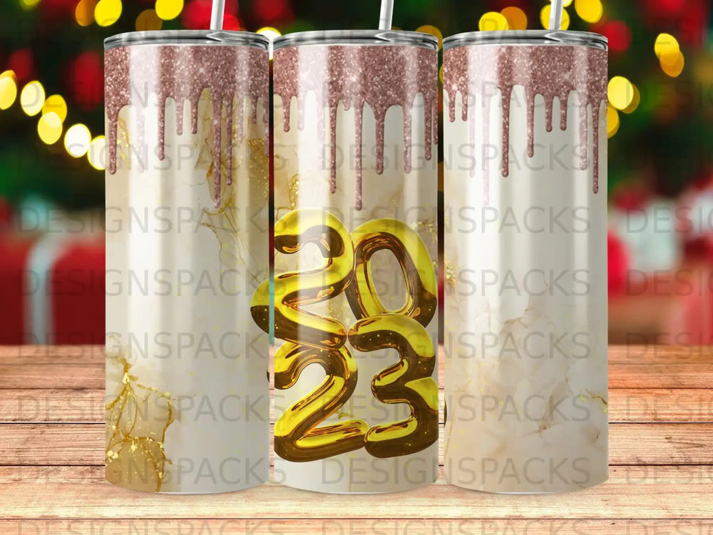 Glitter dripping over gold 2023 on a tumbler.