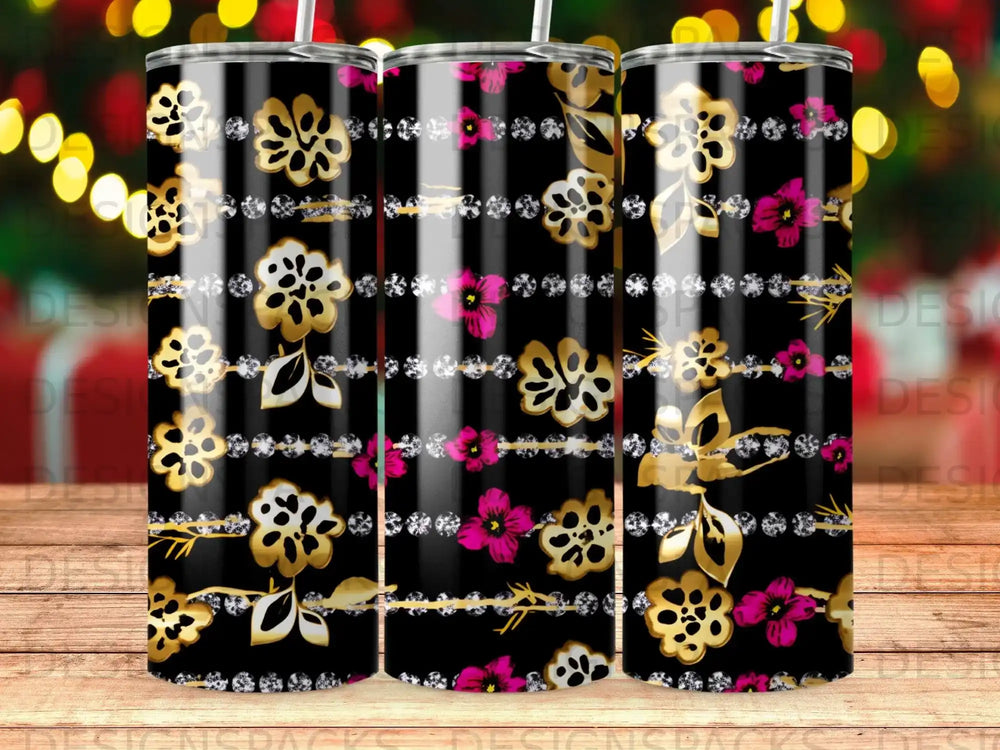 Black tumbler with gold floral and pink flower design, on a blurred bokeh background.