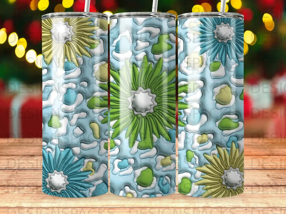 Three tumblers with blue, green, and yellow floral designs on a leopard print background.