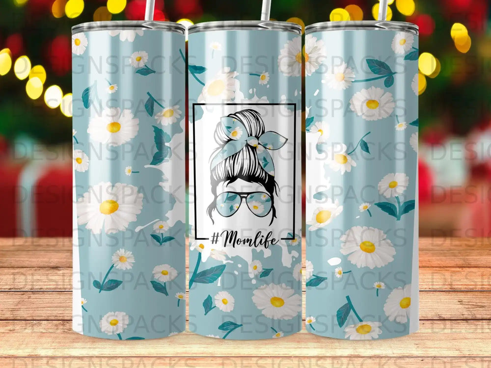 Blue tumbler with white daisies and a graphic of a woman with sunglasses and the text #Momlife.