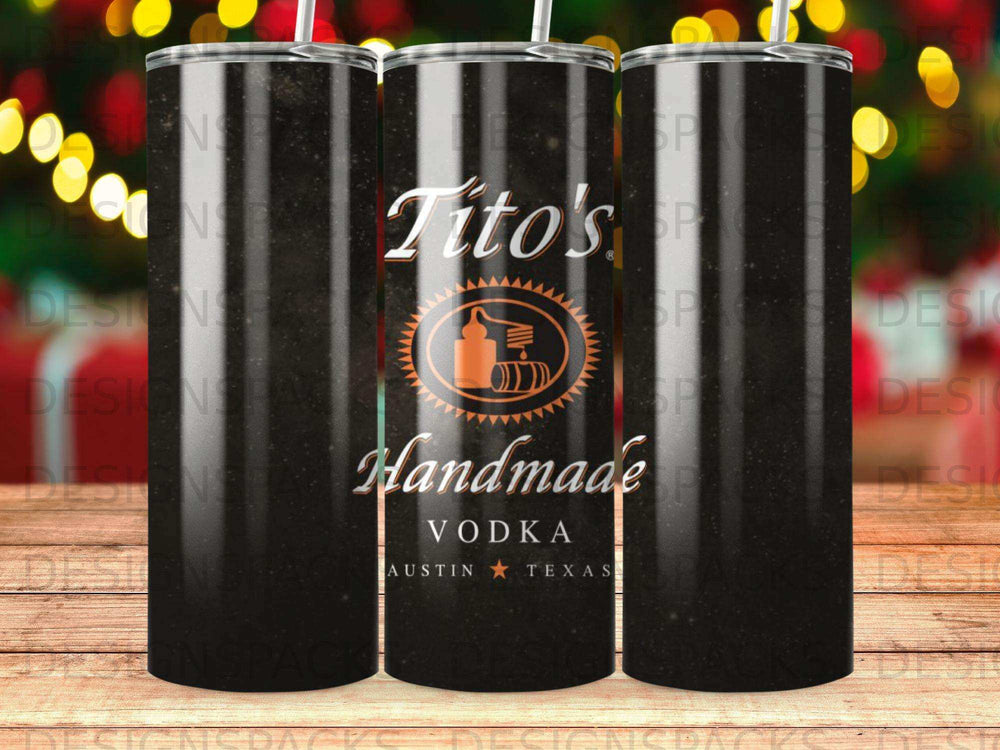 Tito's Handmade Vodka tumbler with logo and festive bokeh background.