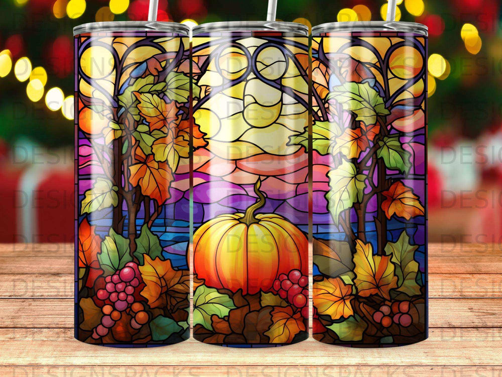 Stained glass tumbler featuring a pumpkin, grapes, and autumn leaves against a sunset.
