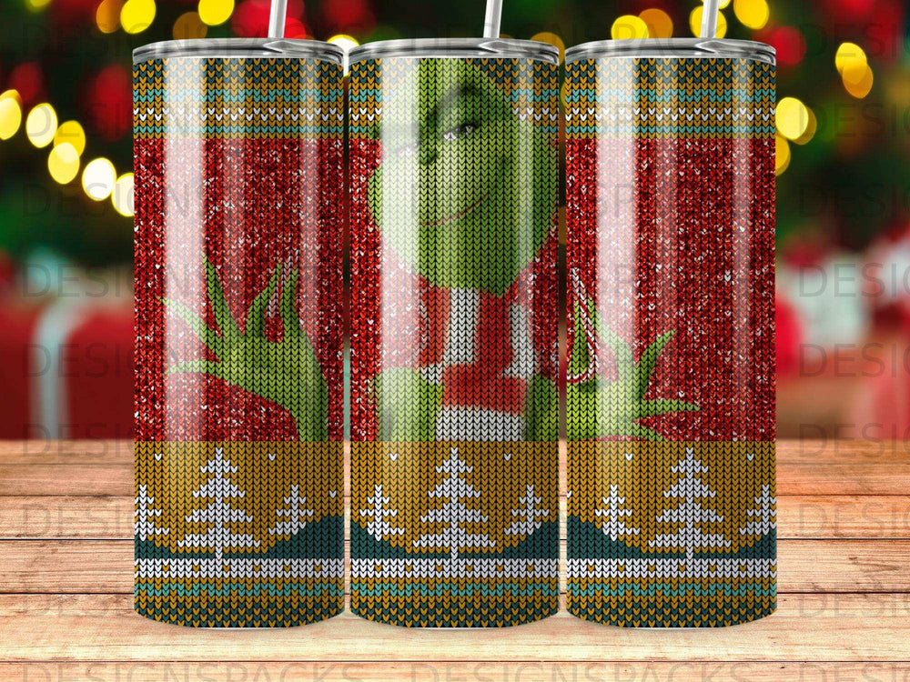 Green Grinch character in a red sweater on a patterned tumbler.