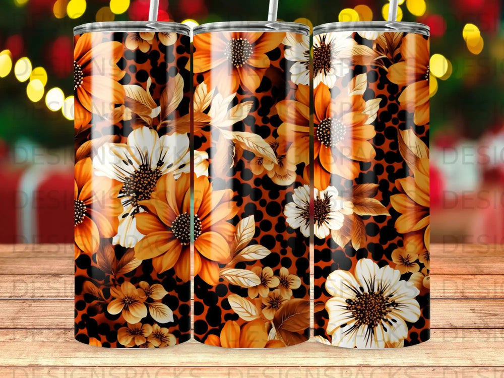 Tumbler with floral pattern featuring orange and white flowers on a black spotted background.