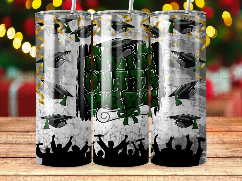 Graduation caps and diploma on a tumbler with cheering crowd silhouettes.