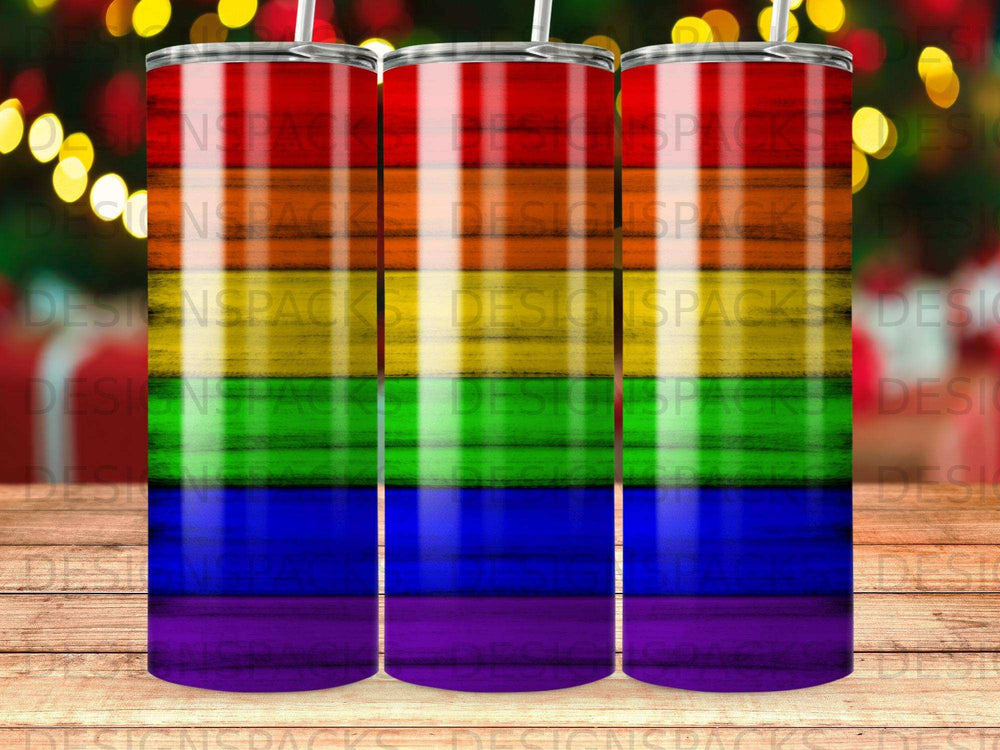 Three tumblers with a rainbow gradient design and a wooden background.