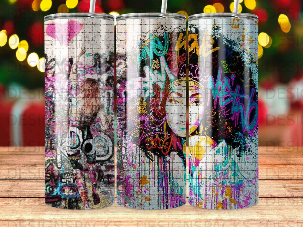 Graffiti art tumbler with colorful abstract faces and spray paint splatters.