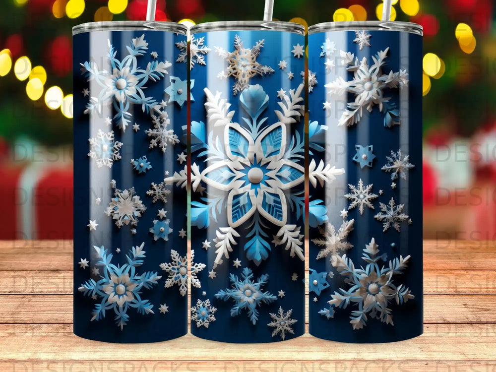 Blue tumbler with white and silver snowflakes against a dark blue background.