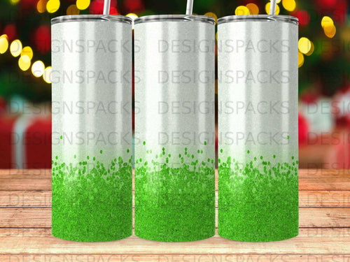 Three green glitter tumblers with a blurred festive background.