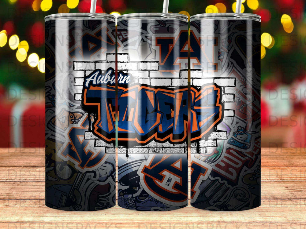 Auburn Tigers graffiti logo on a tumbler with brick and sticker background.