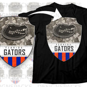 Black t-shirt featuring Florida Gators logo on camouflage shield with orange and blue stripes.